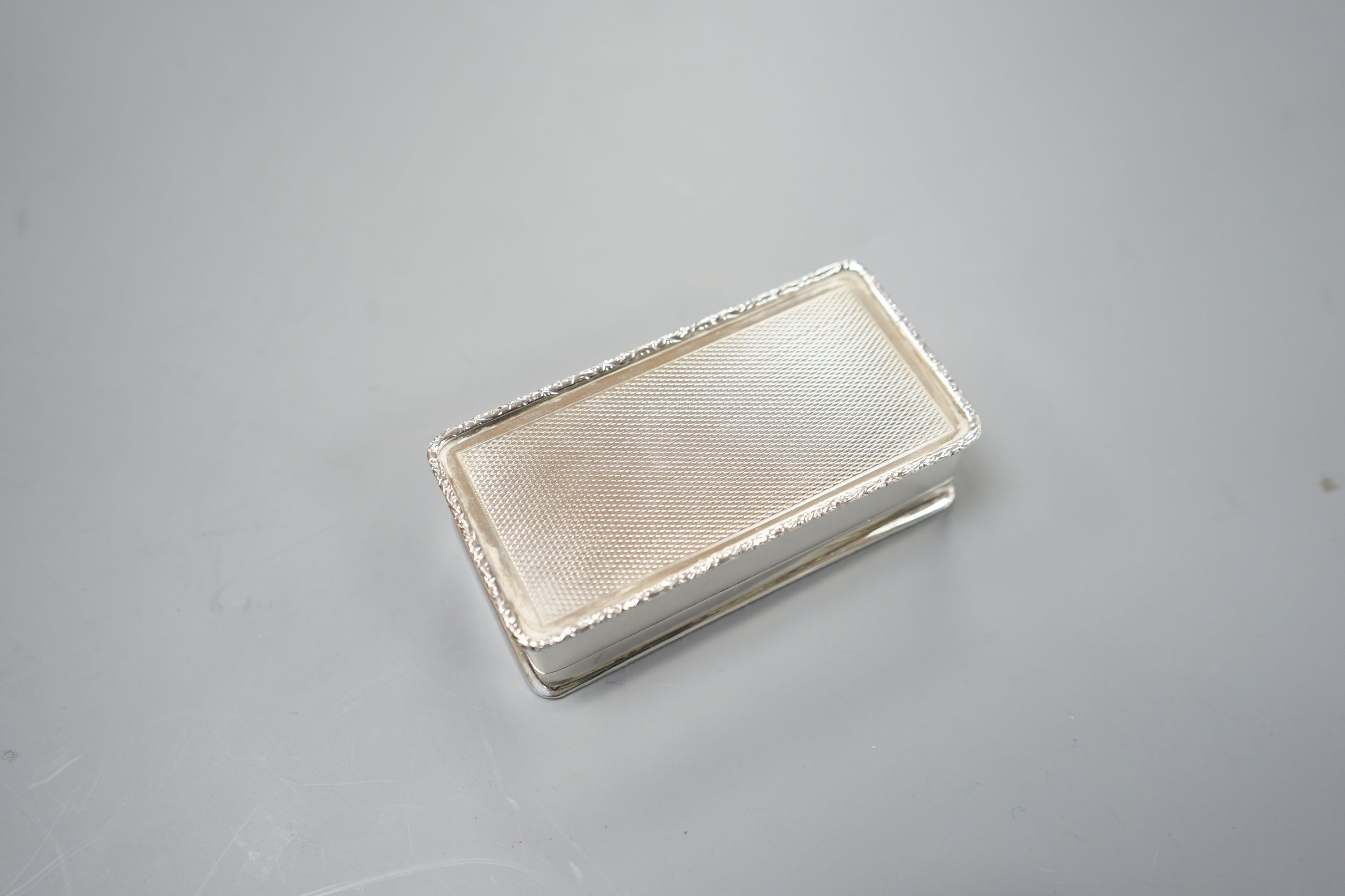 A modern Garrard & Co silver and enamel snuff box, decorated with manor house scene, Birmingham, 1986, 94mm, gross 147 grams.